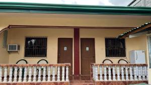 a house with two doors and a balcony at Turtle GuestHouse- White beach in Puerto Galera