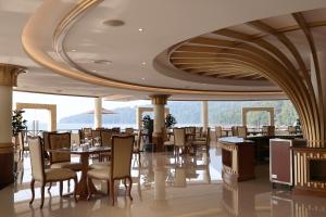 a restaurant with tables and chairs and a large window at Damai Lagoon Resort in Santubong