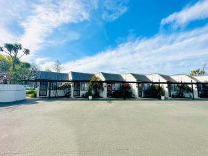 un gran edificio con un estacionamiento delante de él en Gothic Heights Motel, en Christchurch