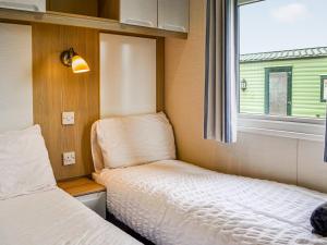 a small room with two beds and a window at Merse Place 4 - Uk45159 in Mainsriddle