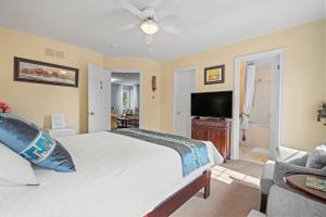 a bedroom with a bed and a flat screen tv at Charlottetown House Bed & Breakfast in Niagara on the Lake