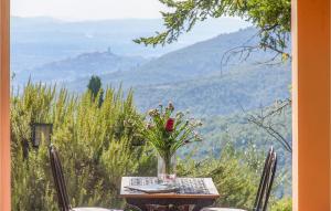 una mesa con un jarrón de flores en la cima de una montaña en Lovely Home In Castiglion Fiorentino, en Castiglion Fiorentino