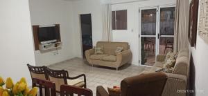 uma sala de estar com sofás e cadeiras e uma televisão em Casa no Centro Bananeiras-PB em Bananeiras