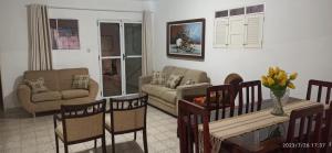 ein Wohnzimmer mit einem Sofa, einem Tisch und Stühlen in der Unterkunft Casa no Centro Bananeiras-PB in Bananeiras