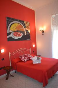 a red bedroom with a bed with a redspread at Anna's Family in Naples