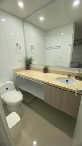a bathroom with a toilet and a sink with a mirror at Habitacion Ciudadela Nio 1 in Neiva