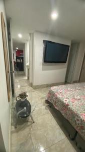 Habitación con cama, mesa y TV. en Habitacion Ciudadela Nio 1, en Neiva