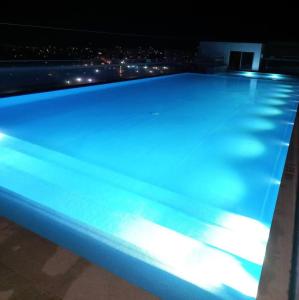 a swimming pool lit up at night at Habitacion Ciudadela Nio 1 in Neiva