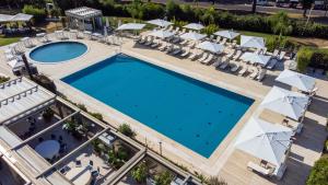 een uitzicht over een zwembad in een resort bij Holiday Inn Rome - Eur Parco Dei Medici, an IHG Hotel in Rome