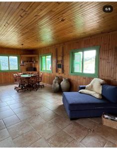 a living room with a blue couch and a table at Pousada Villa dos Vinhedos in São Joaquim