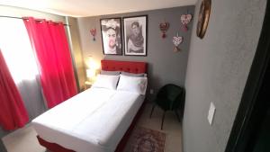 a small bedroom with a bed with a red headboard at Departamento Completo Frente al Aeropuerto in Mexico City