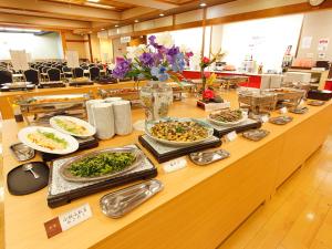 Itoen Hotel Atagawa في هيغاشيزو: بوفيه مع اطباق طعام على طاولة