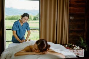 a woman laying in a bed with a nurse at Pang Chompu in Nan