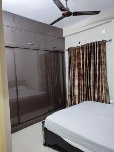 - une chambre avec un lit et un ventilateur de plafond dans l'établissement Rahul guest house, à Visakhapatnam