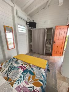 a bedroom with a bed in a room with a door at Casamango in Basse-Terre