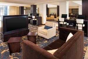 a hotel lobby with couches and a flat screen tv at Sheraton Hartford South in Rocky Hill