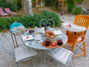 uma mesa com uma chaleira e uma tigela de fruta em Rêve d’Emma em Plan-dʼOrgon