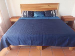 a bed in a room with a blue comforter at Posada Tia Miny in San Miguel
