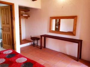 1 dormitorio con espejo en la pared y 1 cama en Posada Tia Miny, en San Miguel