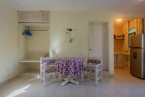 a kitchen with a table and chairs and a refrigerator at Marysol d10 private beach next to nomads in Isla Mujeres