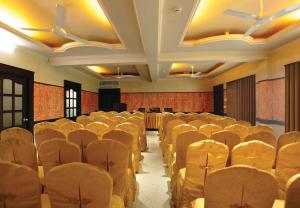 een lege hal met stoelen en tafels erin bij Hotel Maharani in Pala