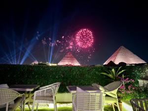 uno spettacolo pirotecnico con piramidi sullo sfondo di notte di Pyramids Top guest house a Il Cairo