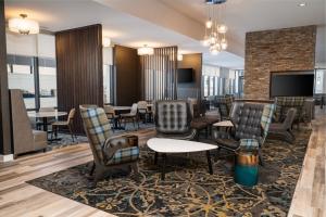 a hotel lobby with chairs and tables and a tv at Residence Inn by Marriott Grand Rapids Downtown in Grand Rapids