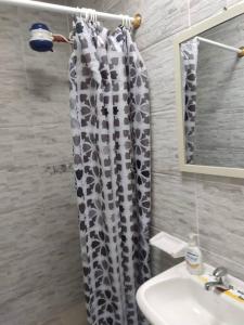 a bathroom with a shower curtain and a sink at SUITE DENTRO DEL CLUB CASA BLANCA EN SAME in Volcán Chimborazo