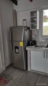 a kitchen with a stainless steel refrigerator in a kitchen at SUITE DENTRO DEL CLUB CASA BLANCA EN SAME in Volcán Chimborazo