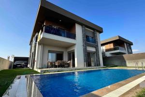 una casa con piscina frente a una casa en Modern Luxury Villa, en Antalya