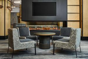 a lobby with two chairs and a table and a tv at The Westin Denver Downtown in Denver