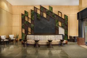 a lobby with a bench and tables and chairs at The Westin Denver Downtown in Denver