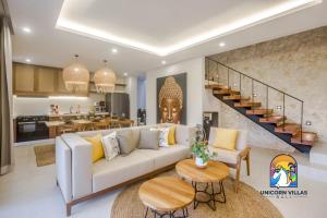 a living room with a white couch and a staircase at Villa Rufina - by Unicorn Villas Bali in Canggu