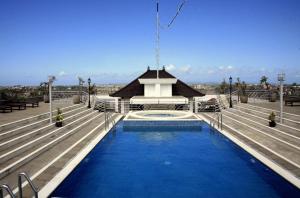 a swimming pool with a building in the background at Bali Paradise City Hotel in Denpasar