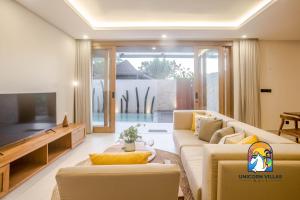 a living room with a couch and a tv at Villa Rufina - by Unicorn Villas Bali in Canggu