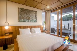 a bedroom with a large white bed in a room at Villa Rufina - by Unicorn Villas Bali in Canggu