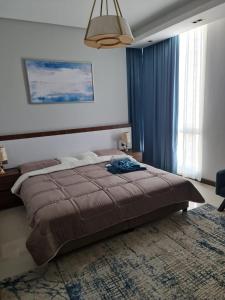 um quarto com uma cama grande e uma janela grande em شقة مفروشة جديدة مؤثثة بالكامل بالجفير em Manama