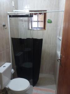 a bathroom with a toilet and a shower at 1 Casa piso superior e 1 Kitnet Térrea, individuais, o estacionamento área comum in Bertioga