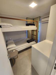 Kleines Zimmer mit 2 Etagenbetten und einem Schreibtisch. in der Unterkunft Apartamento Beach Class Muro Alto in Porto De Galinhas