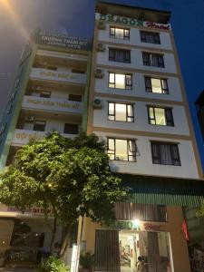 ハロンにあるDragon hotelの前に木がある背の高い白い建物