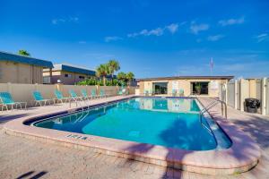 ココアビーチにあるCocoa Beach Condo with Community Pool and Hot Tub!の椅子と建物のあるプール