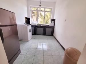 La cuisine est équipée d'un réfrigérateur blanc et d'un évier. dans l'établissement Lovely Apartment in Relaxing Homey Environment, à Pannipitiya