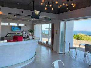 a kitchen with a bar with a view of the ocean at Support Inn Minami-Chita Annex Hamachaya in Minamichita