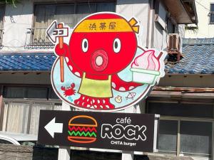 um sinal para uma rocha de café com um monstro vermelho nela em Support Inn Minami-Chita Annex Hamachaya em Minamichita