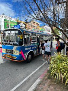 um grupo de pessoas em pé fora de um ônibus em Labkoff cafe and Hostel em Kanchanaburi