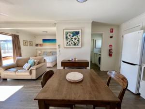 a living room with a table and a refrigerator at Gowings of Mallacoota in Mallacoota