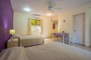 una camera da letto con due letti, un tavolo e una finestra di Marysol d11 private beach next to nomads a Isla Mujeres