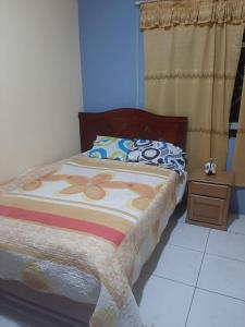 una camera con letto e comodino con sidro di servizio. di CASA DE CAMPO EL AMAZONICO a Tingo María