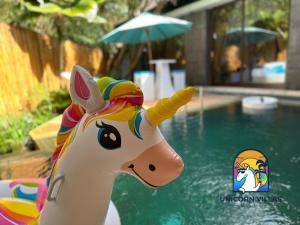 a toy unicorn in front of a swimming pool at Villa di Sawah - by Unicorn Villas Bali in Kerobokan