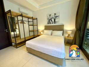 a bedroom with a large bed with white sheets at Villa di Sawah - by Unicorn Villas Bali in Kerobokan